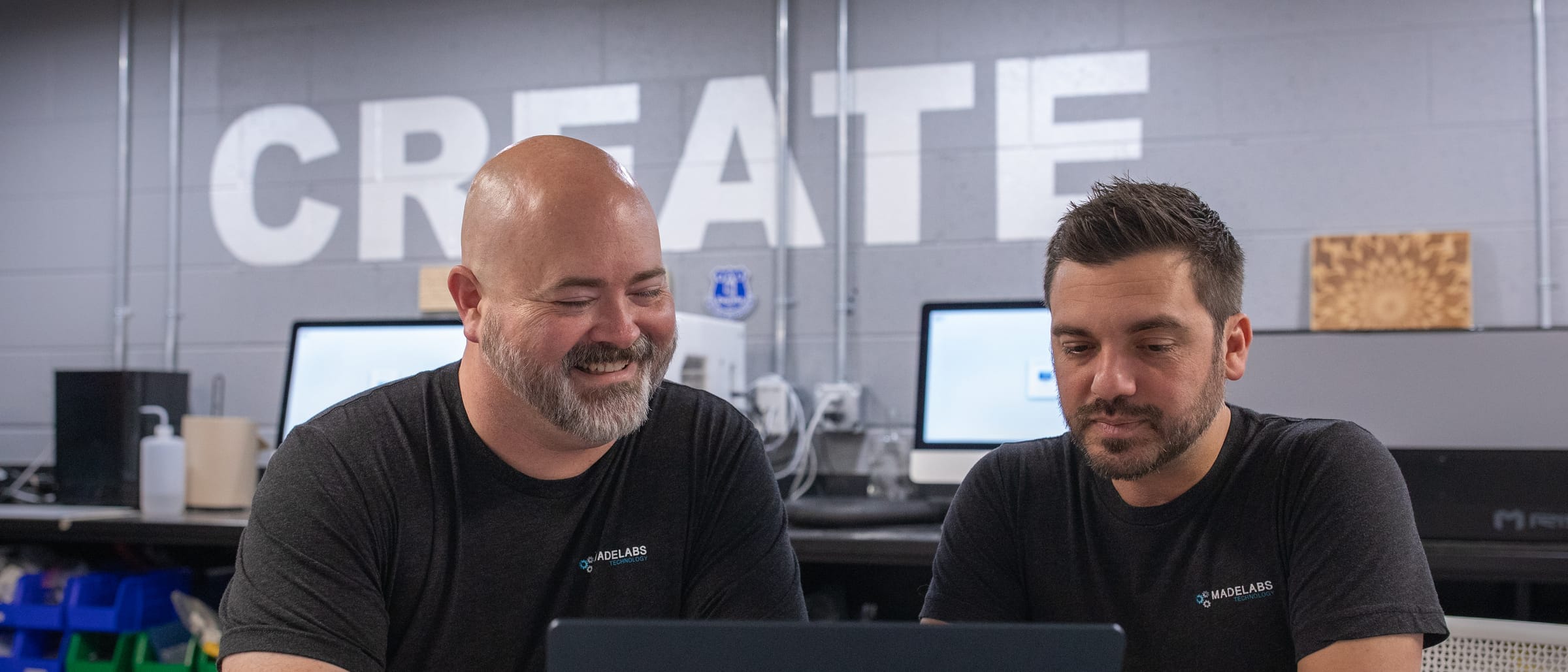 Adam Broadbent and Nicholas Barger, MadeLabs' founders, working through a problem together at a laptop in the MadeLabs office